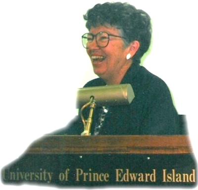 Elizabeth Waterston A laughing woman stands behind a podium at the University of Prince Edward Island.