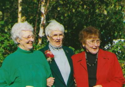 Maud, Amy, and Georgie Campbell. Three women standing arm in arm.