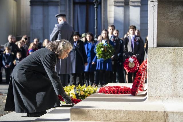 Andrea McKenzie Andrea McKenzie is placing a wreath of poppies on the steps of the white marble Cenotaph.