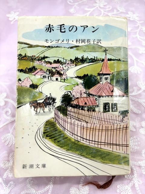 Photo by Kazuko Sakuma. A Japanese book cover featuring an ink and watercolour illustration of a countryside village.