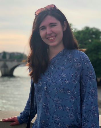 Zoe Kempf-Harris standing in front of a body of water. She is smiling.