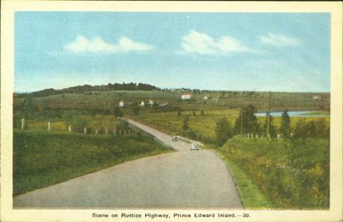 A postcard of the Rustico highway, PEI. A road with two cars goes through the image getting smaller in the distance. Fields are on both sides. 